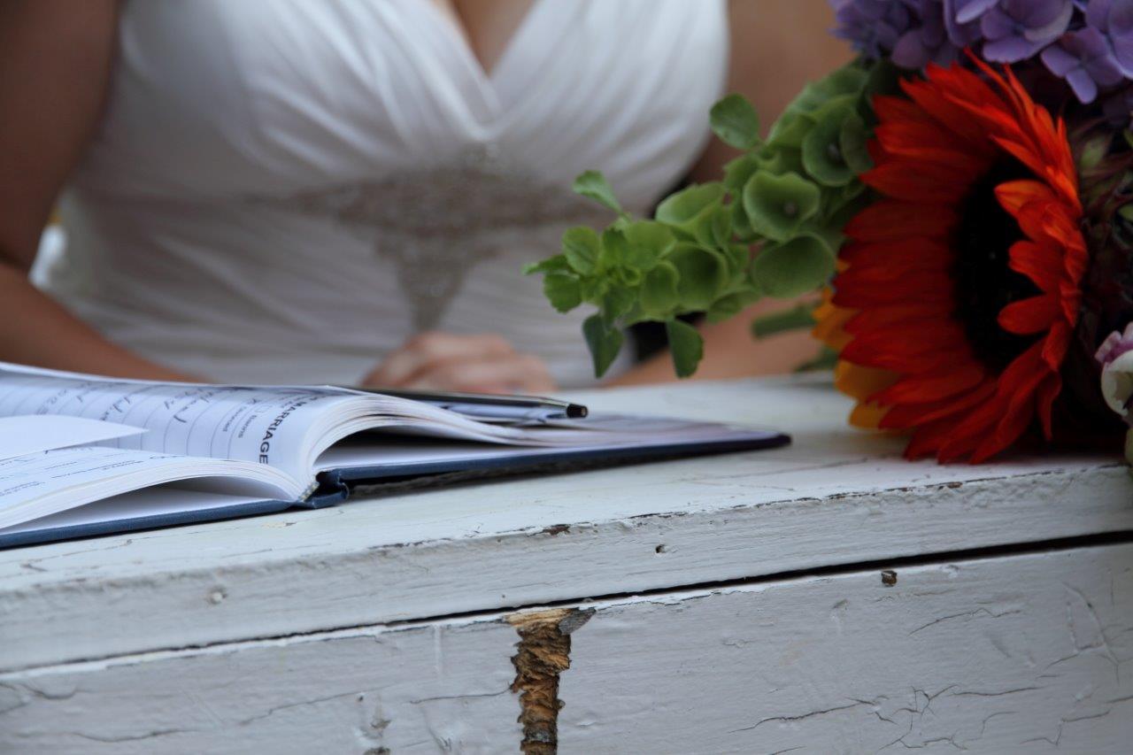 A bride signs the wedding certificate