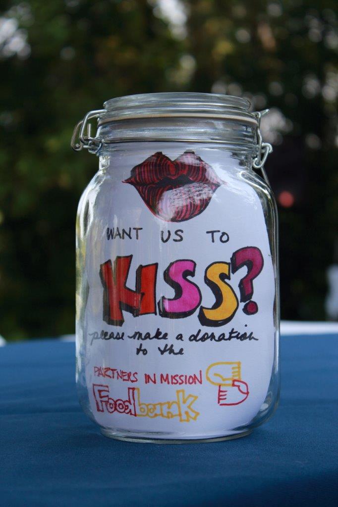 A kissing jar with instructions for guests to donate money to Partners in Mission