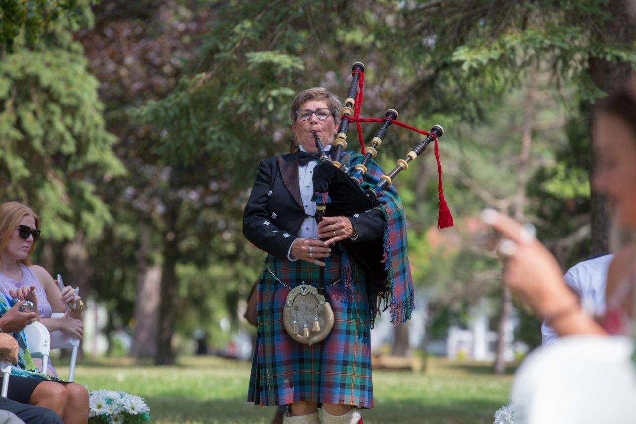 A bagpiper plays while walking down the aisle