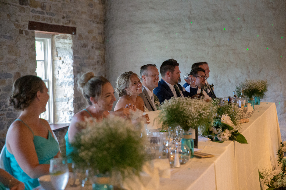 Head table at wedding reception, with baby's breath and seaglass centrepieces