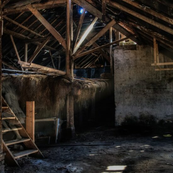 Inside of a dirty barn with water on the floor