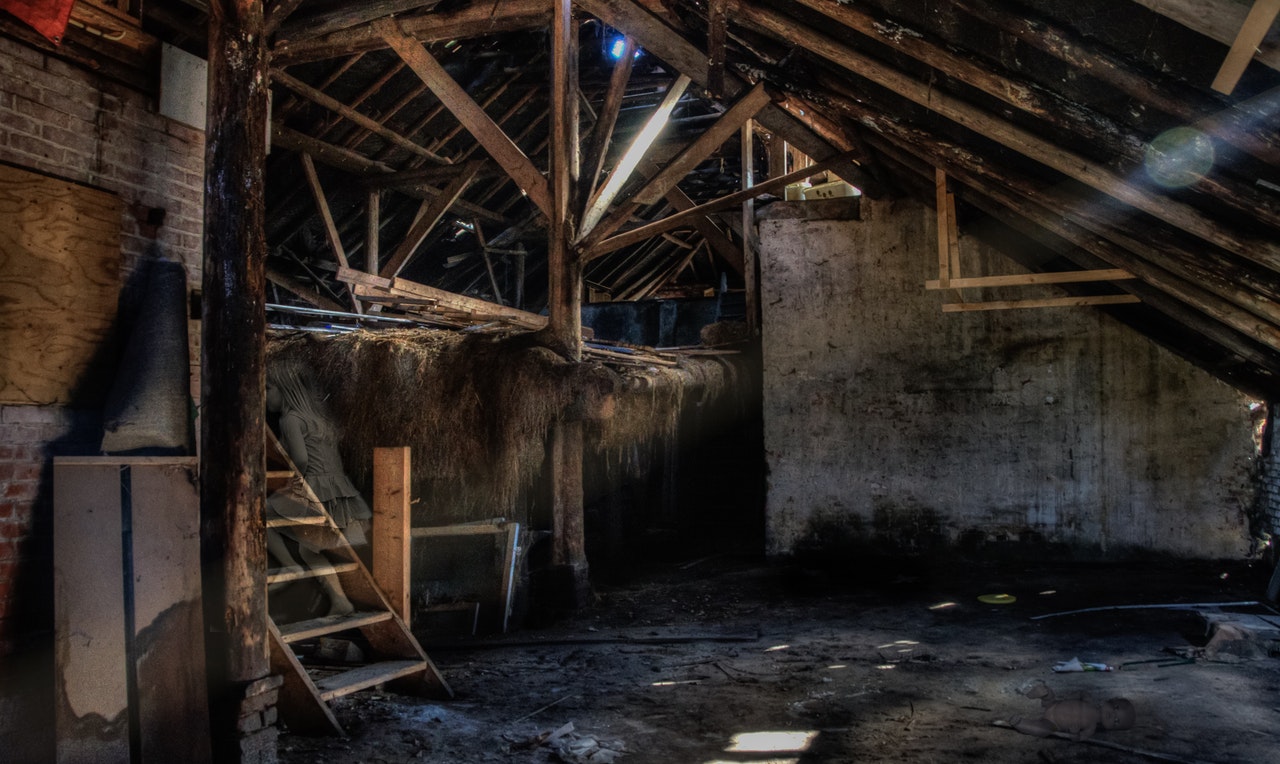 Inside of a dirty barn with water on the floor